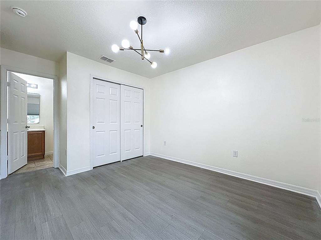 3135 Tocoa Circle Kissimmee, FL 34746 - Photo 32 of 36 an empty room with wooden floor and ceiling fan