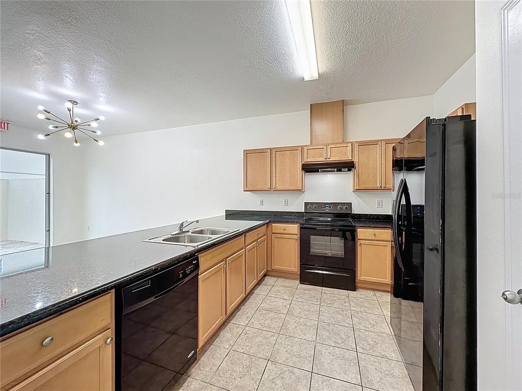 3135 Tocoa Circle Kissimmee, FL 34746 - Photo 4 of 36 a kitchen with granite countertop a sink and stainless steel appliances