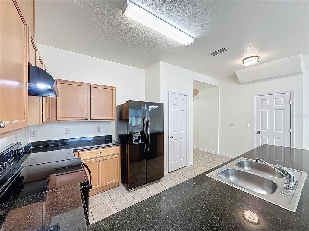 3135 Tocoa Circle Kissimmee, FL 34746 - Photo 6 of 36 a kitchen with stainless steel appliances granite countertop a refrigerator and a sink