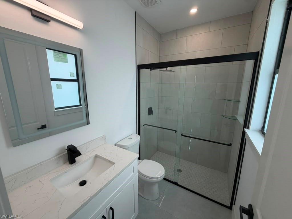 907 Homestead Road South Lehigh Acres, FL 33974 - Photo 37 of 43 Modern bathroom featuring a white vanity with a quartz-finish countertop and an undermount sink