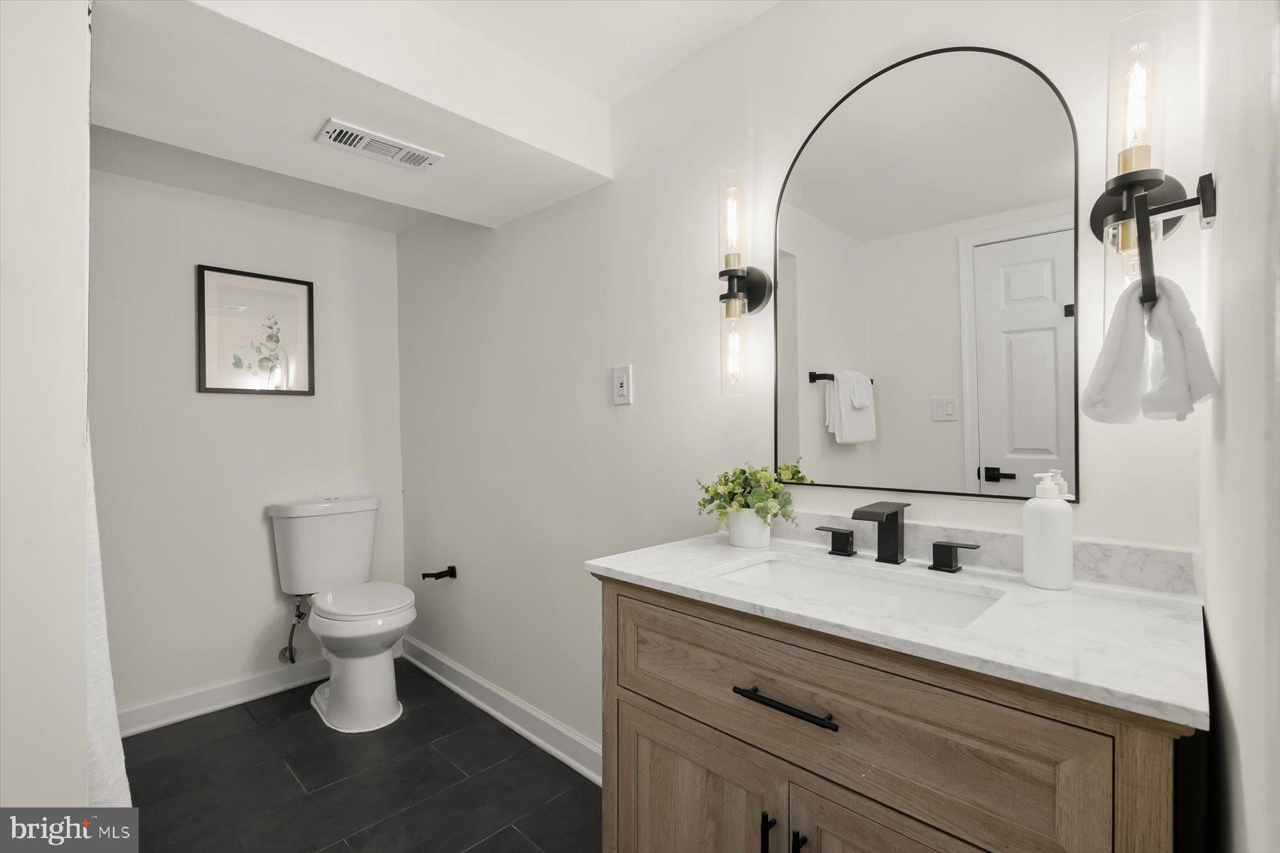 518 Church Street Baltimore, MD 21225 - Photo 21 of 27 a bathroom with a sink a toilet and a mirror