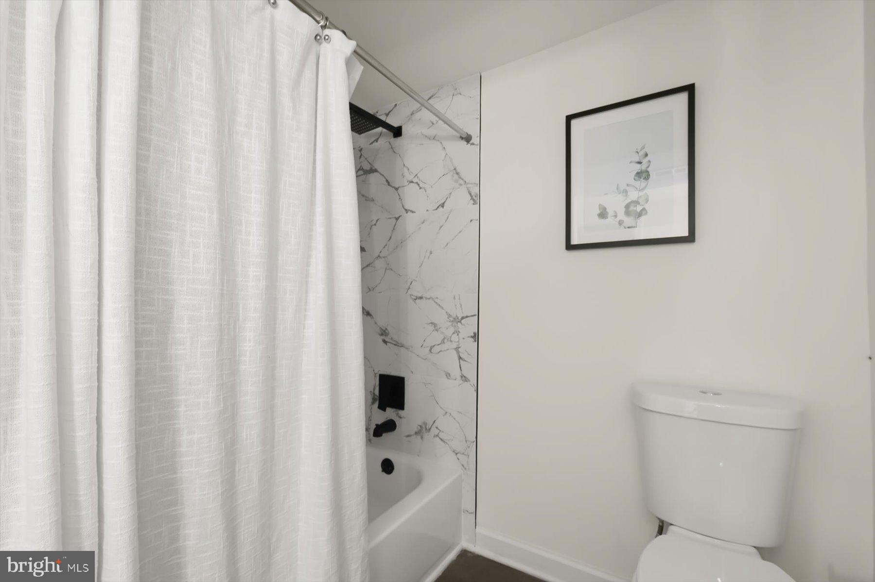 518 Church Street Baltimore, MD 21225 - Photo 22 of 27 a bathroom with a toilet and a shower curtain