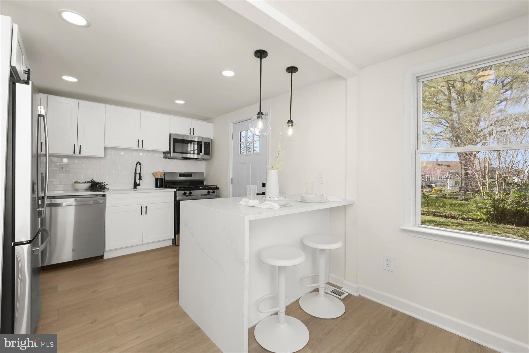 518 Church Street Baltimore, MD 21225 - Photo 8 of 27 a kitchen with white cabinets and stainless steel appliances