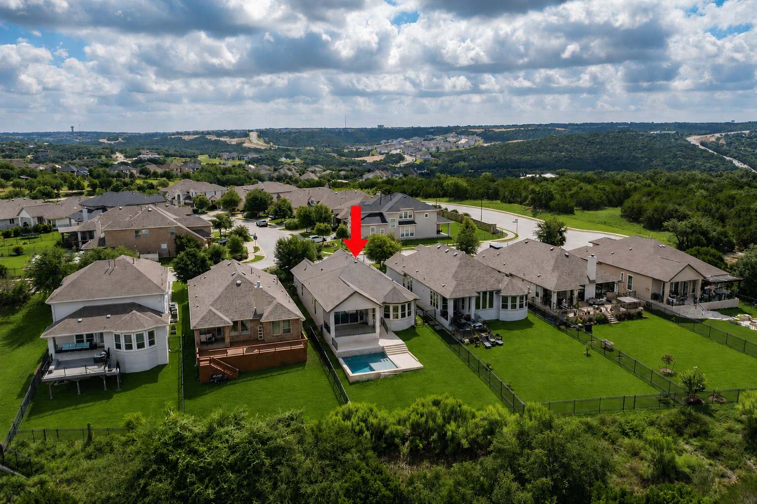 2617 Milan Meadows Drive Leander, TX 78641 - Photo 35 of 40 An aerial perspective showcases a neighborhood with private pools and lush green yards against a backdrop of distant hills.