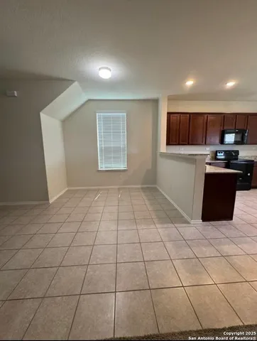 a kitchen with granite countertop a rug a stove a microwave and a counter top space