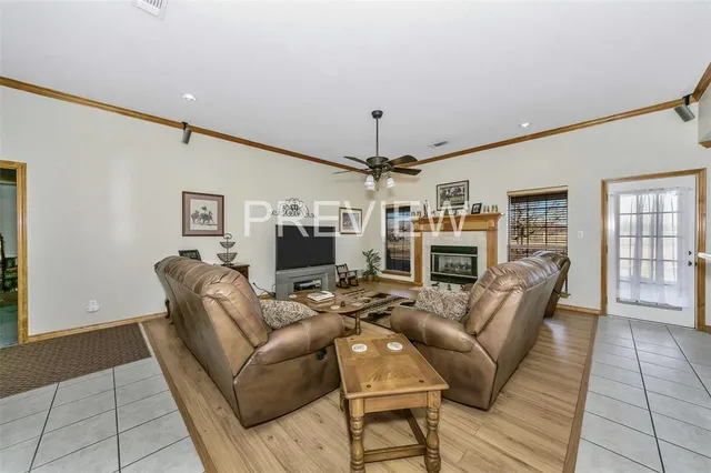 a living room with furniture a fireplace and a dining table with wooden floor