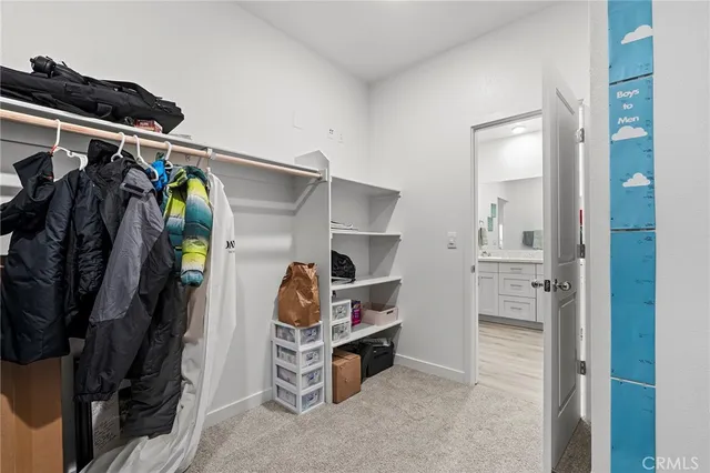a view of walk in closet with clothes and shoes