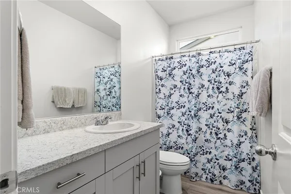 a bathroom with a granite countertop toilet a sink and a shower