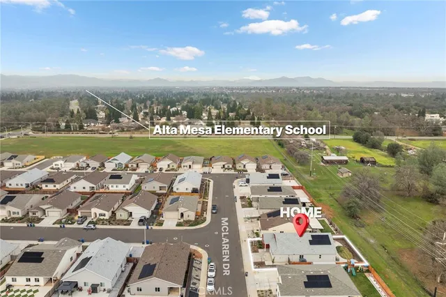 an aerial view of a city with lots of residential buildings ocean and mountain view in back