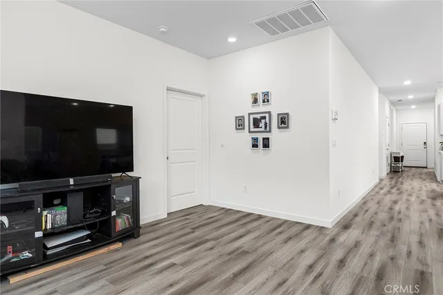 a view of a livingroom with wooden floor and a flat screen tv
