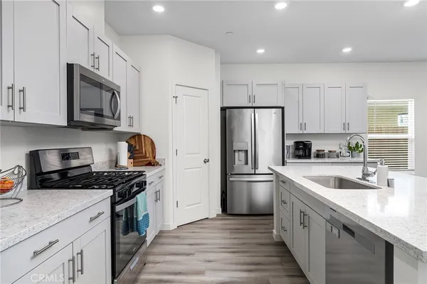 a kitchen with stainless steel appliances granite countertop a sink stove and refrigerator