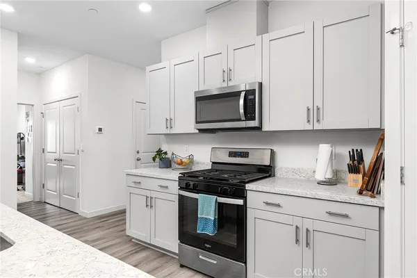 a kitchen with stainless steel appliances granite countertop a sink a stove a microwave and cabinets