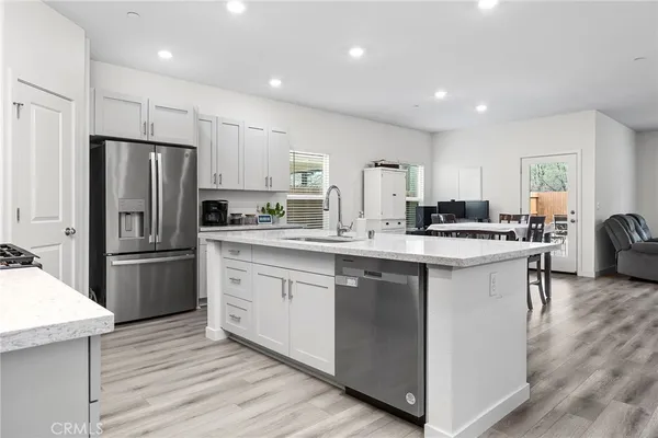 a kitchen with a refrigerator a sink a stove a microwave a counter top space and cabinets