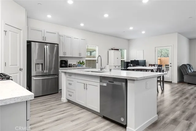 a kitchen with a refrigerator a sink a stove a microwave a counter top space and cabinets