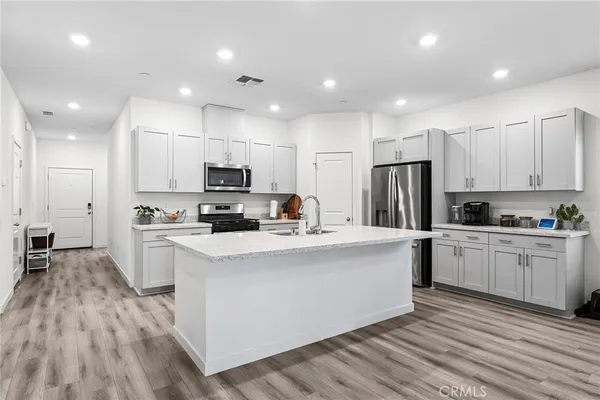 a kitchen with white cabinets and stainless steel appliances