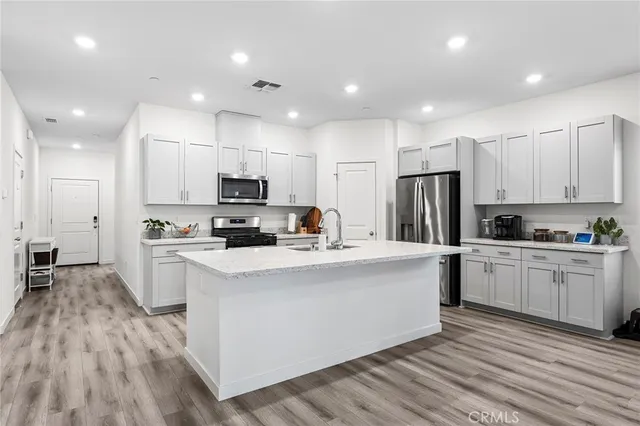 a kitchen with white cabinets and stainless steel appliances