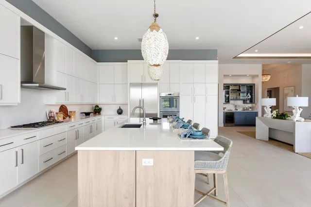 a kitchen with kitchen island granite countertop a sink cabinets and stainless steel appliances