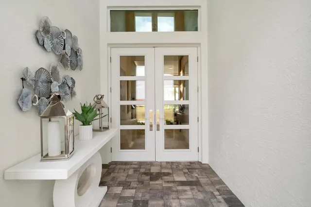 a view of a hallway with windows and chandelier