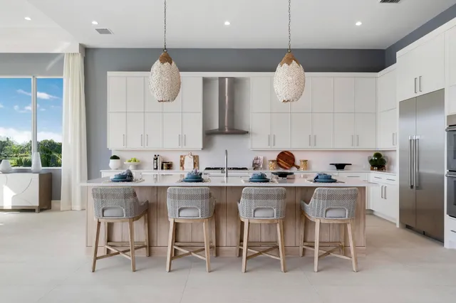 a kitchen with white cabinets and chairs
