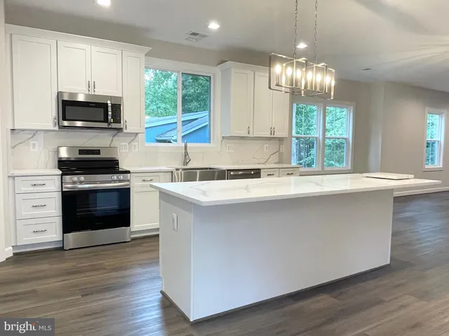 a kitchen with stainless steel appliances a stove sink and microwave