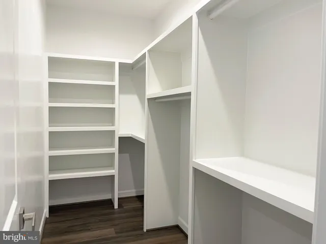 a view of walk in closet with empty racks