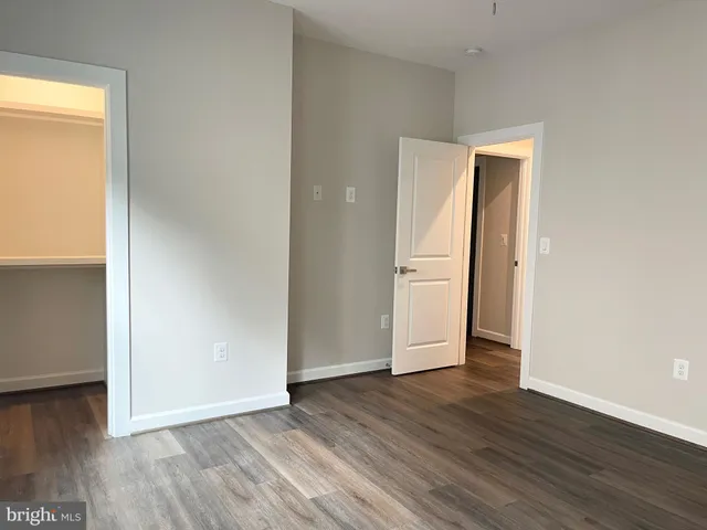 an empty room with wooden floor and closet