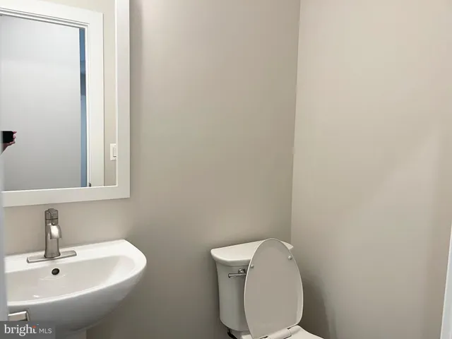 a bathroom with a toilet a sink and mirror