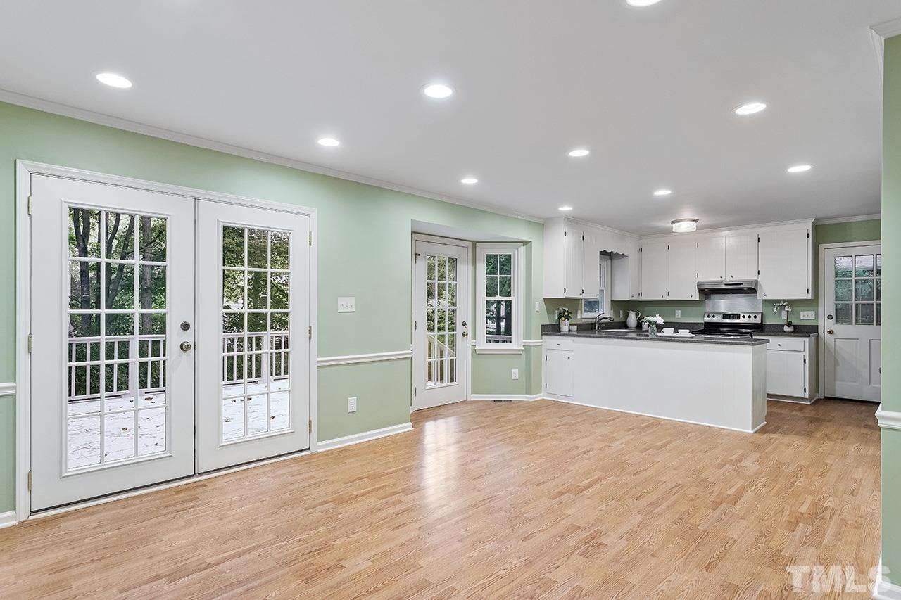 7416 Old Fox Trail Raleigh, NC 27613 - Photo 12 of 26 a large white kitchen with kitchen island a sink stainless steel appliances and cabinets