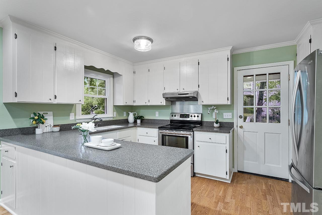 7416 Old Fox Trail Raleigh, NC 27613 - Photo 17 of 26 a kitchen with sink a stove and cabinets