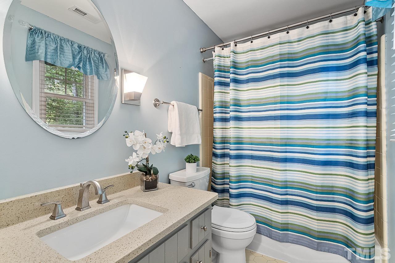 7416 Old Fox Trail Raleigh, NC 27613 - Photo 19 of 26 a bathroom with a sink a toilet and a mirror