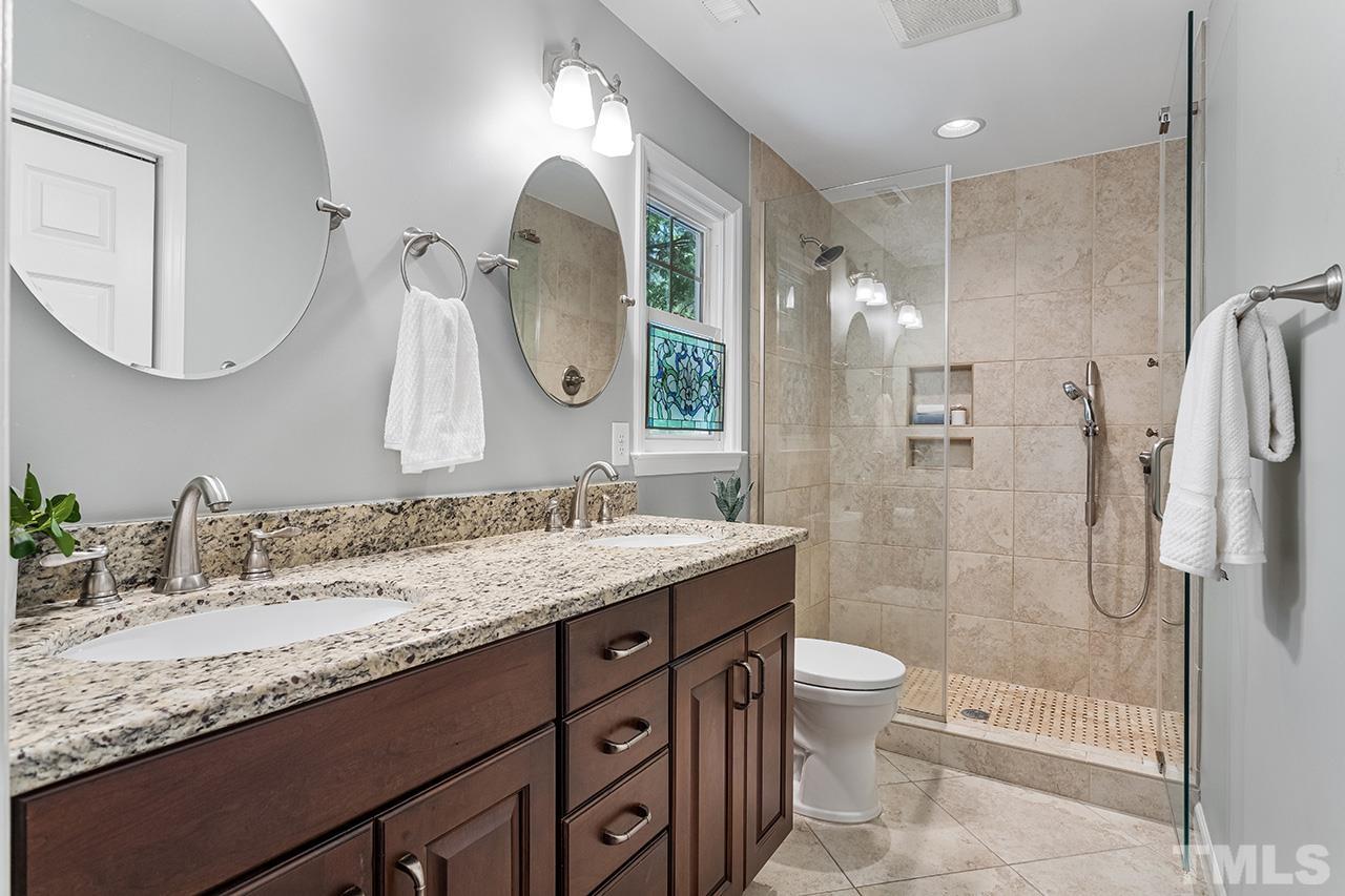 7416 Old Fox Trail Raleigh, NC 27613 - Photo 25 of 26 a bathroom with a granite countertop sink toilet and shower