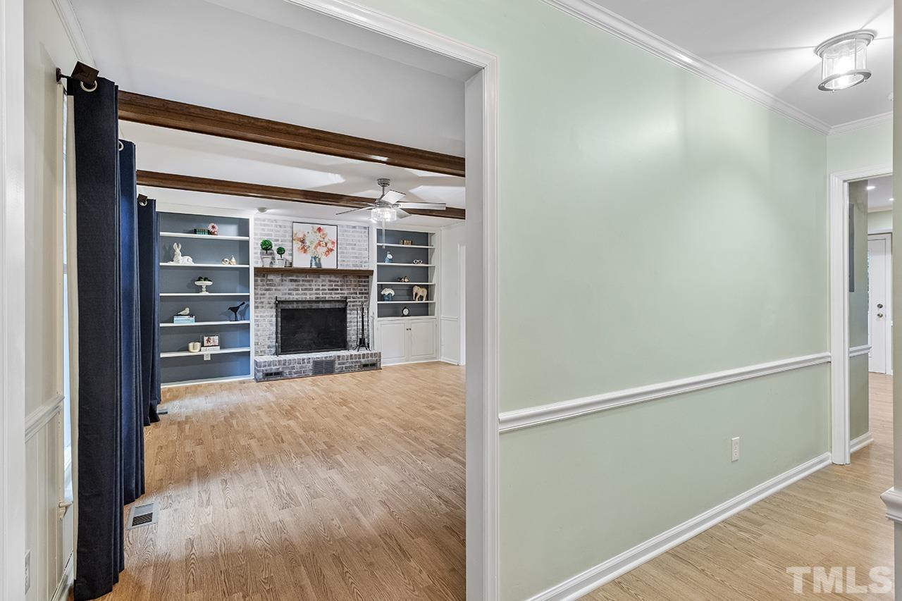 7416 Old Fox Trail Raleigh, NC 27613 - Photo 7 of 26 a view of empty room with wooden floor and fireplace
