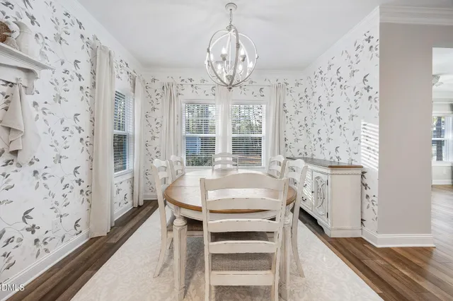 a kitchen with granite countertop white cabinets stainless steel appliances and wooden floor