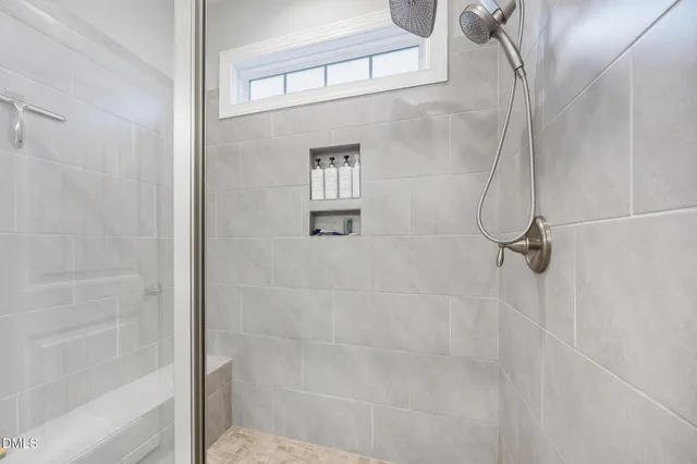 a bedroom with a bed a window and a flat screen television