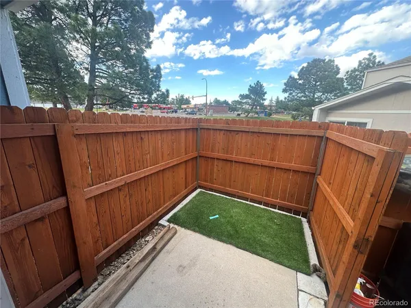 a view of a backyard with wooden fence