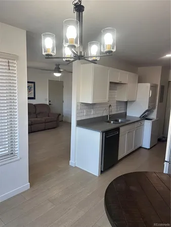 a kitchen with kitchen island granite countertop a sink cabinets and stainless steel appliances
