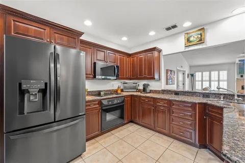 a kitchen with stainless steel appliances granite countertop a refrigerator and a stove top oven