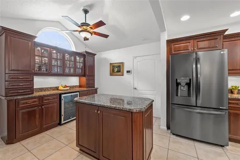a kitchen with stainless steel appliances granite countertop a refrigerator a stove and a sink