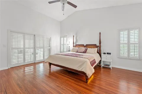 a bedroom with a large bed and wooden floor