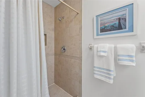 a view of a hallway with closet and paintings on the wall