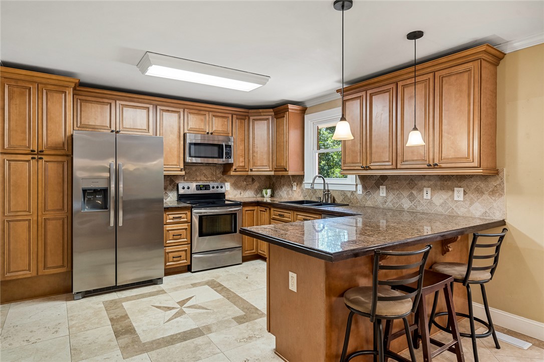 512 East Fredericks Street Anderson, SC 29621 - Photo 9 of 31 A well-lit kitchen presents a functional island with bar seating, complemented by ample cabinetry and modern appliances.
