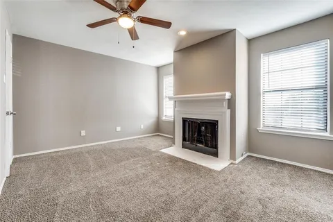 a view of a livingroom with a fireplace and a chandelier fan