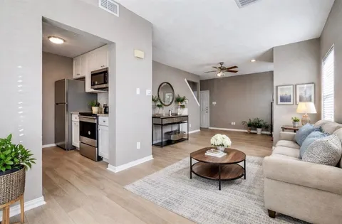 a living room with furniture a rug and kitchen view