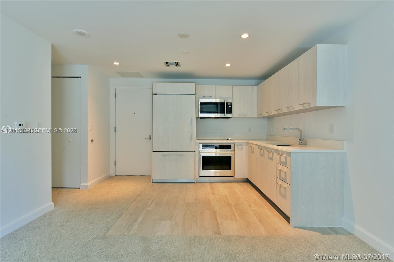 45 Southwest 9th Street, Unit 1907 Miami, FL 33130 - Photo 1 of 16 a kitchen with white cabinets and white appliances
