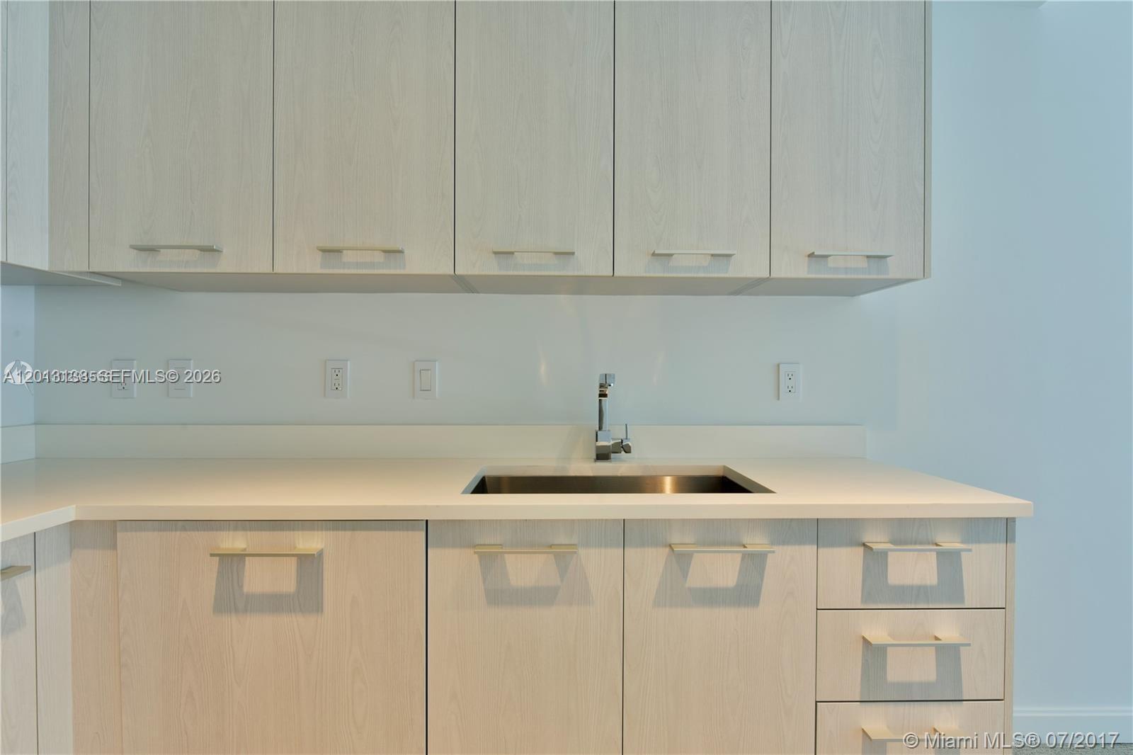 45 Southwest 9th Street, Unit 1907 Miami, FL 33130 - Photo 2 of 16 a kitchen with white cabinets