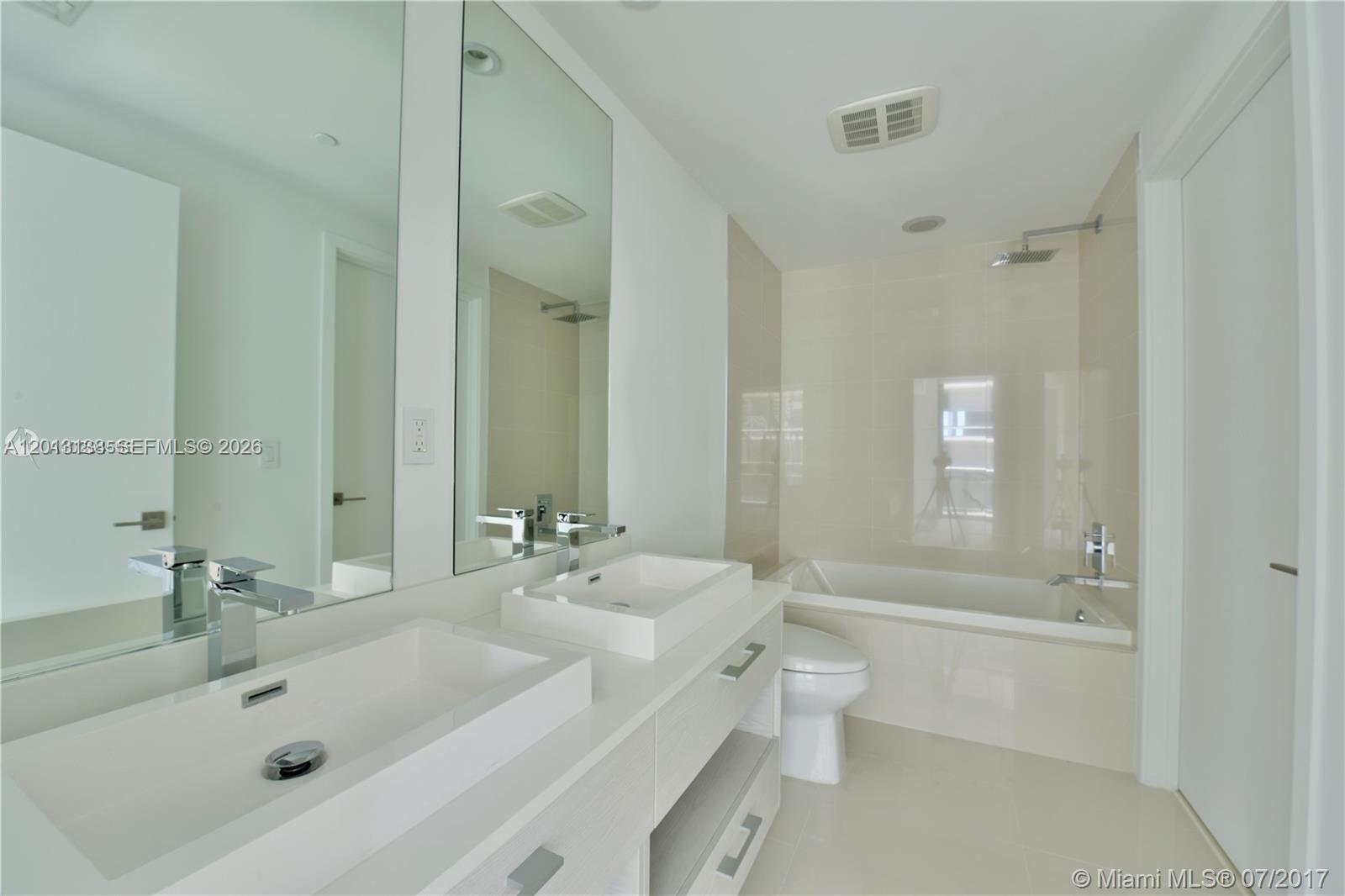45 Southwest 9th Street, Unit 1907 Miami, FL 33130 - Photo 7 of 16 a bathroom with a tub sink toilet and a mirror