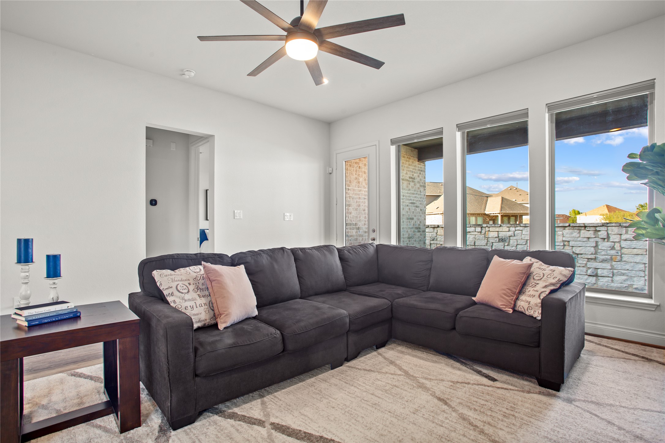369 Cold Riv Run Kyle, TX 78640 - Photo 18 of 40 Living area with a ceiling fan and a wall of windows.