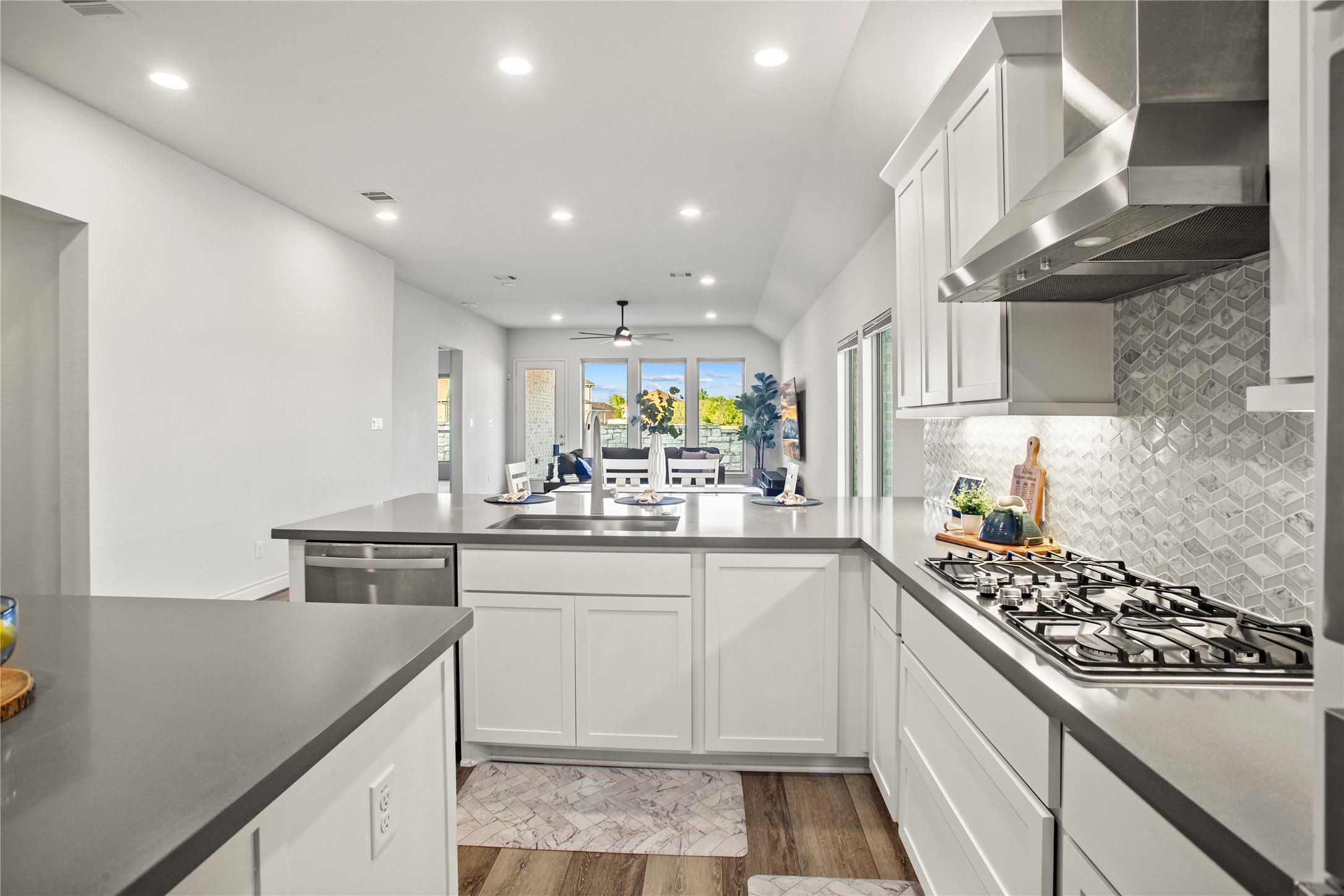 369 Cold Riv Run Kyle, TX 78640 - Photo 22 of 40 Kitchen featuring white cabinets, recessed lighting, light wood-style flooring, a peninsula, and stainless steel appliances