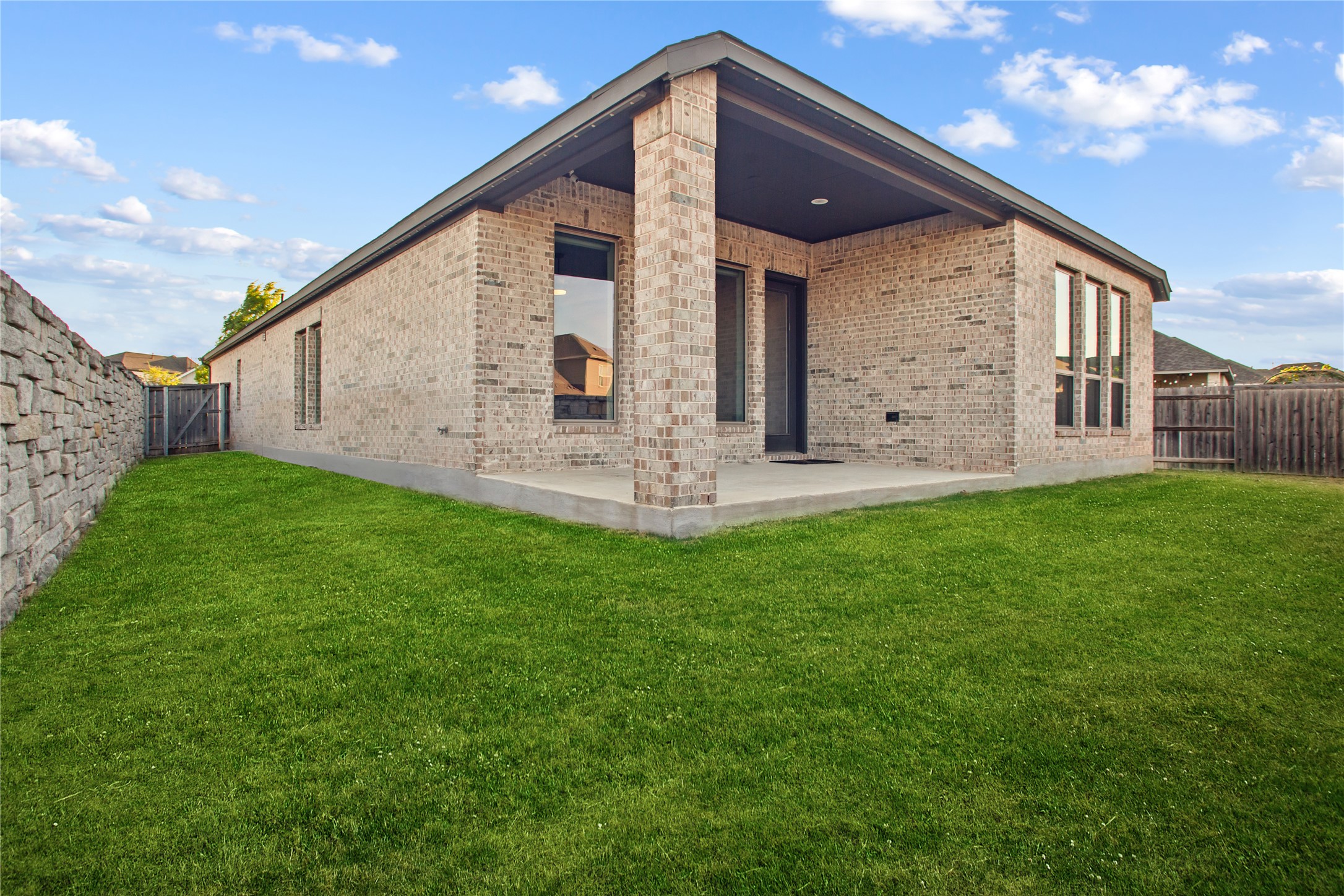 369 Cold Riv Run Kyle, TX 78640 - Photo 27 of 40 Back of home featuring brick siding, a fenced backyard, a patio area, and a gate.