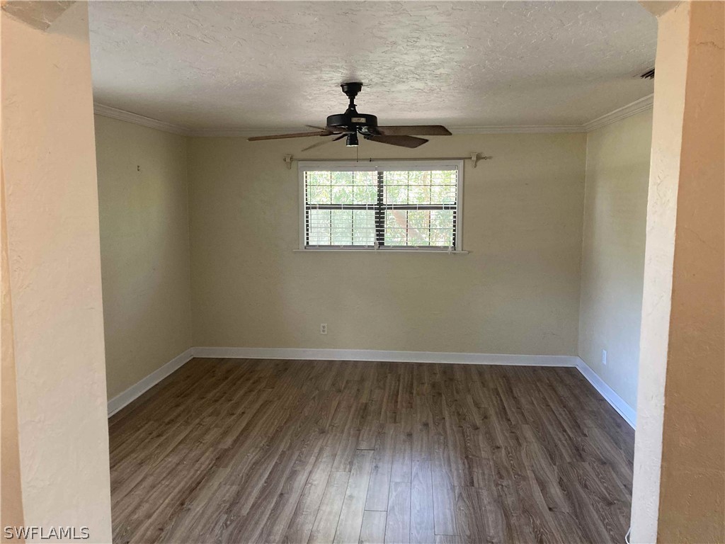 8429 Cardinal Road Fort Myers, FL 33967 - Photo 3 of 16 wooden floor in an empty room with a window